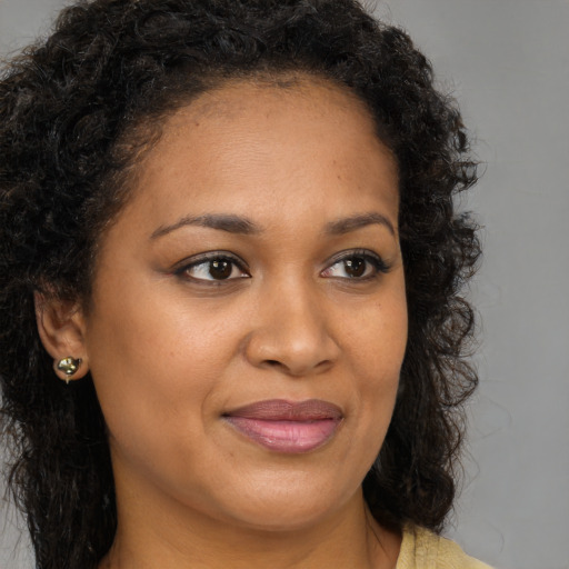 Joyful black young-adult female with long  brown hair and brown eyes