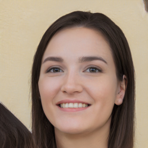 Joyful white young-adult female with long  brown hair and brown eyes