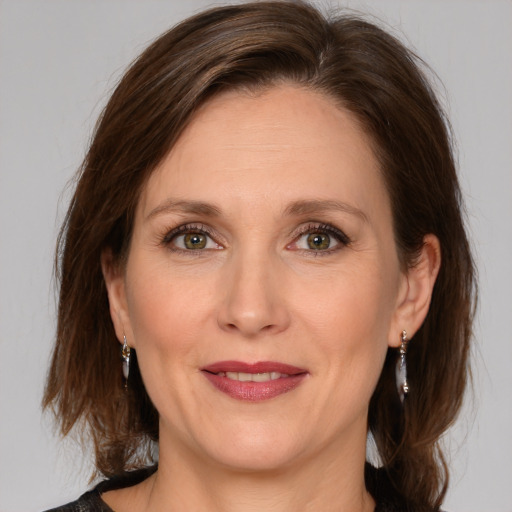 Joyful white adult female with medium  brown hair and grey eyes