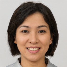 Joyful asian young-adult female with medium  brown hair and brown eyes