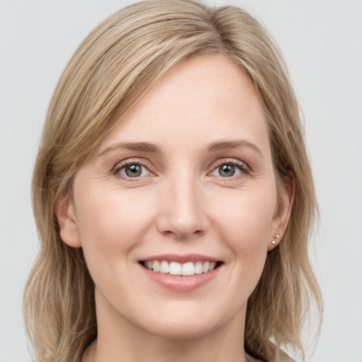 Joyful white young-adult female with medium  brown hair and blue eyes