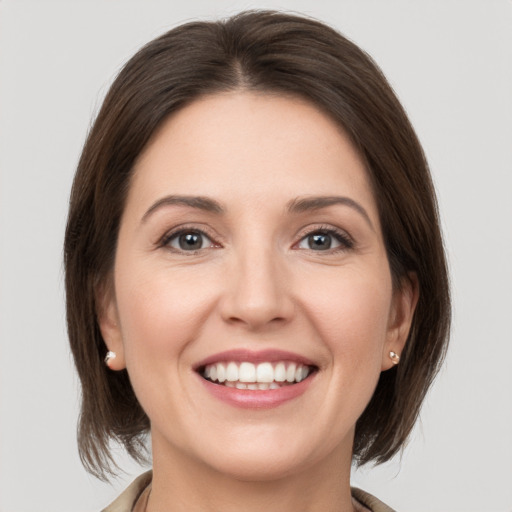 Joyful white young-adult female with medium  brown hair and grey eyes