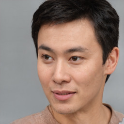 Joyful asian young-adult male with short  brown hair and brown eyes