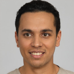 Joyful latino young-adult male with short  black hair and brown eyes