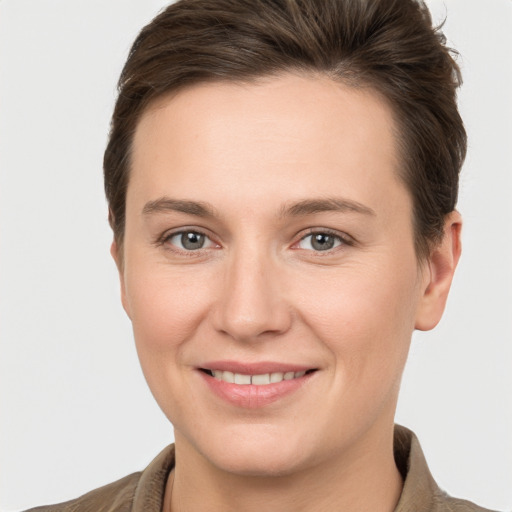 Joyful white young-adult female with short  brown hair and grey eyes