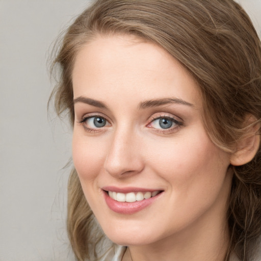 Joyful white young-adult female with medium  brown hair and blue eyes