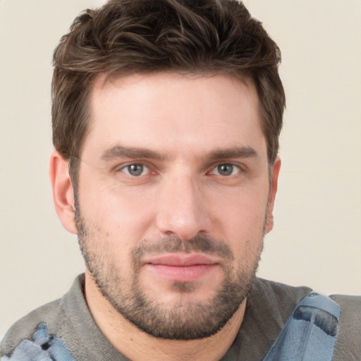 Joyful white young-adult male with short  brown hair and grey eyes