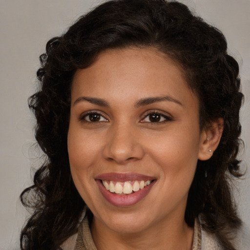 Joyful latino young-adult female with long  brown hair and brown eyes