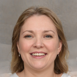 Joyful white adult female with medium  brown hair and blue eyes