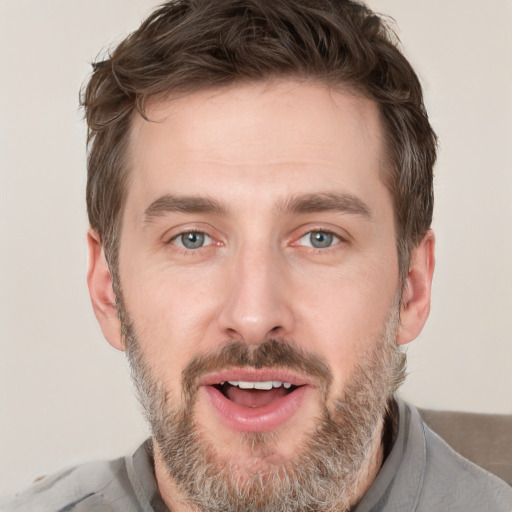 Joyful white young-adult male with short  brown hair and grey eyes