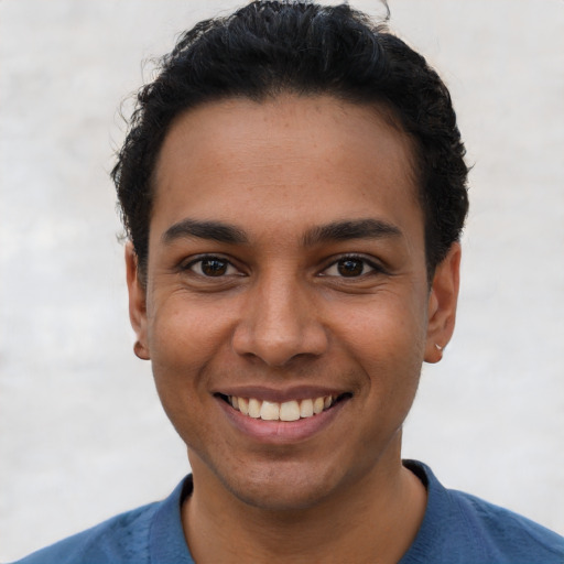 Joyful latino young-adult male with short  black hair and brown eyes