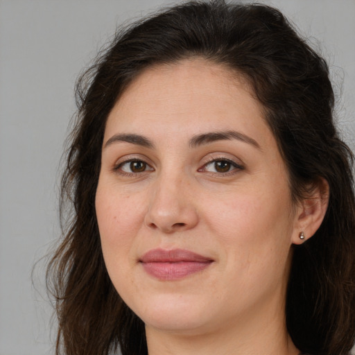 Joyful white adult female with long  brown hair and brown eyes