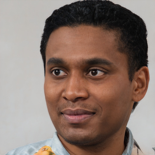 Joyful black young-adult male with short  black hair and brown eyes