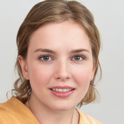 Joyful white young-adult female with medium  brown hair and blue eyes