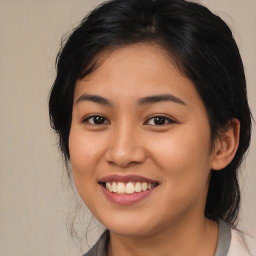 Joyful asian young-adult female with medium  brown hair and brown eyes