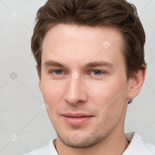 Joyful white young-adult male with short  brown hair and grey eyes