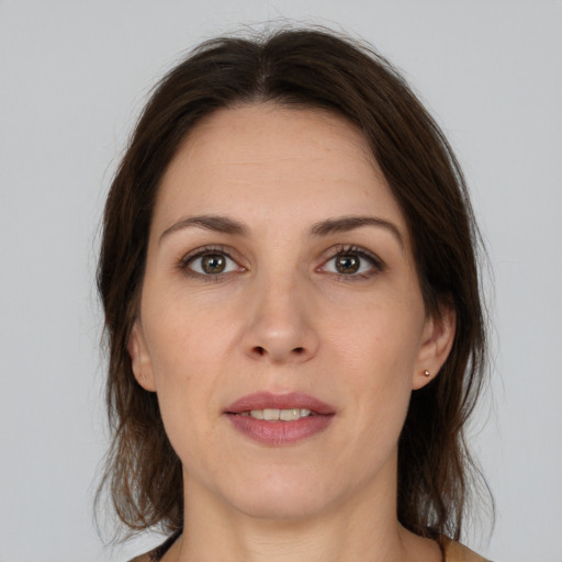 Joyful white adult female with medium  brown hair and brown eyes