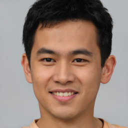 Joyful asian young-adult male with short  brown hair and brown eyes