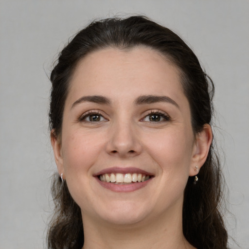 Joyful white young-adult female with long  brown hair and grey eyes