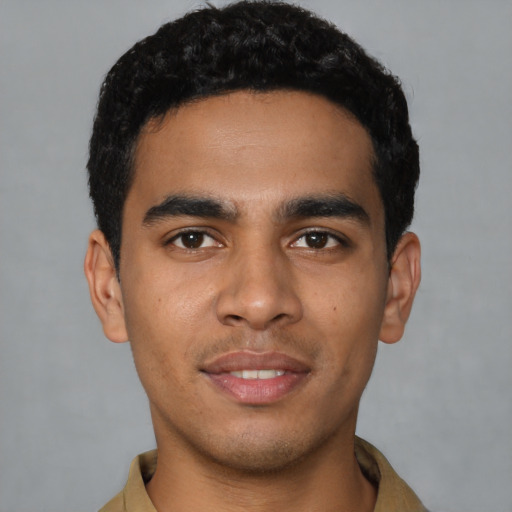 Joyful latino young-adult male with short  black hair and brown eyes