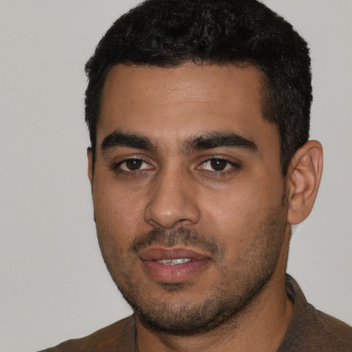 Joyful latino young-adult male with short  black hair and brown eyes