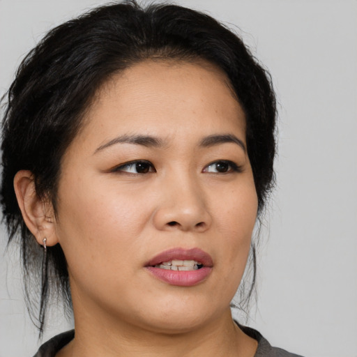 Joyful asian young-adult female with medium  black hair and brown eyes