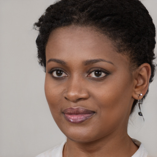 Joyful black young-adult female with long  brown hair and brown eyes
