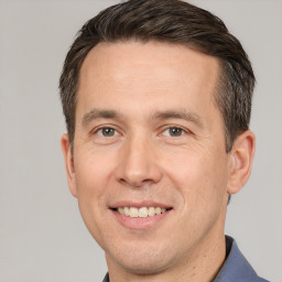 Joyful white adult male with short  brown hair and brown eyes