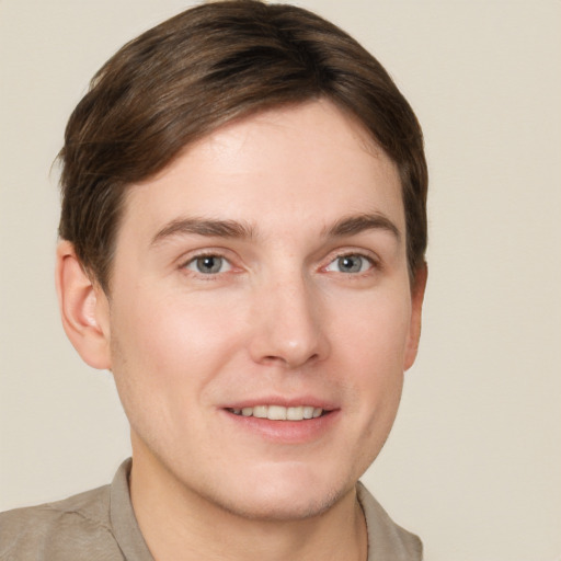 Joyful white young-adult male with short  brown hair and grey eyes