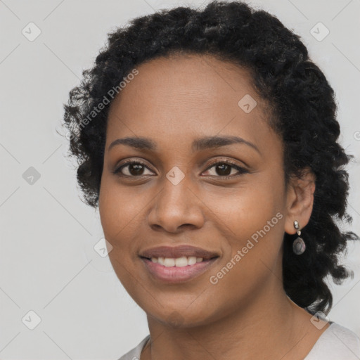 Joyful black young-adult female with long  black hair and brown eyes