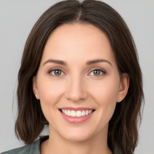 Joyful white young-adult female with long  brown hair and brown eyes