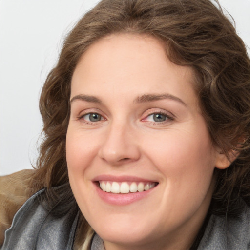 Joyful white young-adult female with long  brown hair and blue eyes