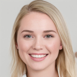 Joyful white young-adult female with long  brown hair and blue eyes