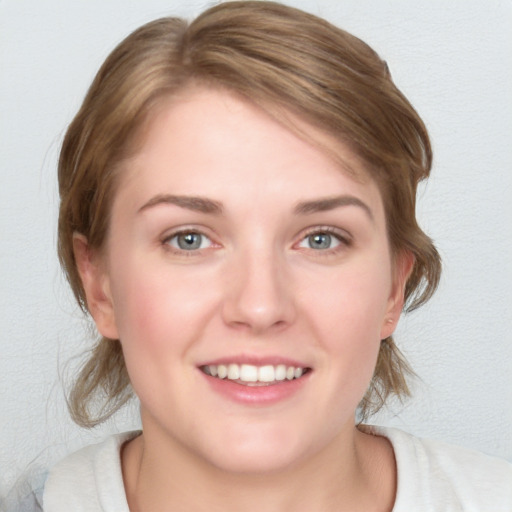 Joyful white young-adult female with medium  brown hair and blue eyes