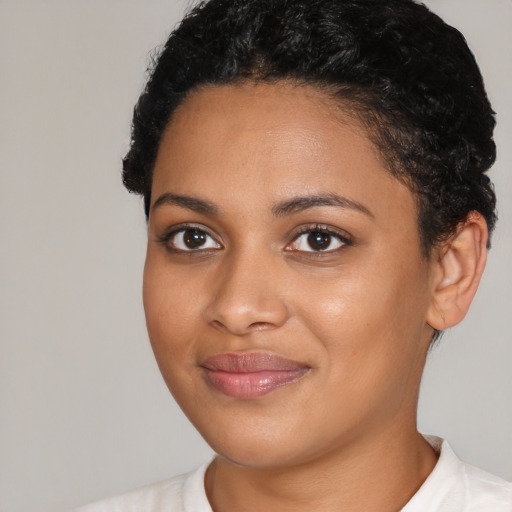 Joyful black young-adult female with short  black hair and brown eyes