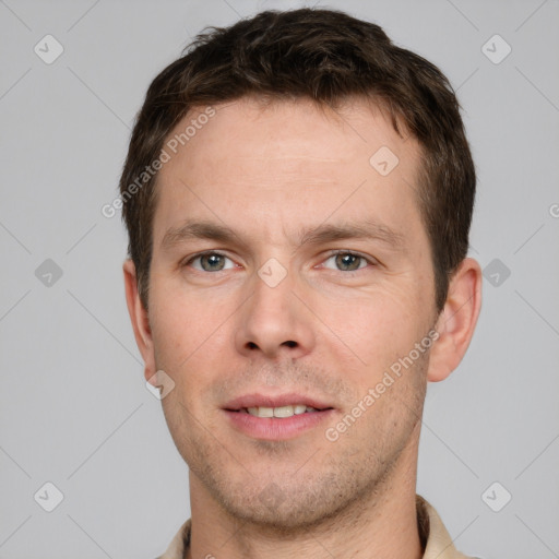 Joyful white young-adult male with short  brown hair and grey eyes