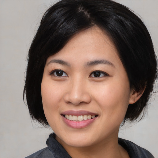 Joyful asian young-adult female with medium  black hair and brown eyes