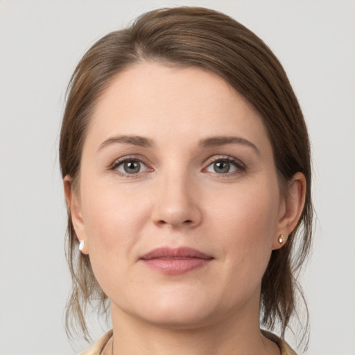 Joyful white young-adult female with medium  brown hair and grey eyes