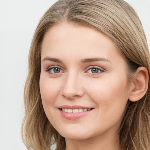 Joyful white young-adult female with long  brown hair and blue eyes