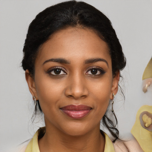 Joyful black young-adult female with medium  black hair and brown eyes