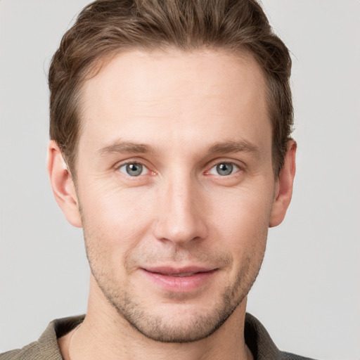 Joyful white young-adult male with short  brown hair and grey eyes