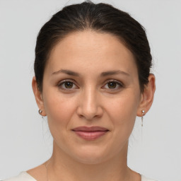 Joyful white young-adult female with medium  brown hair and grey eyes