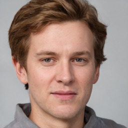 Joyful white young-adult male with short  brown hair and grey eyes