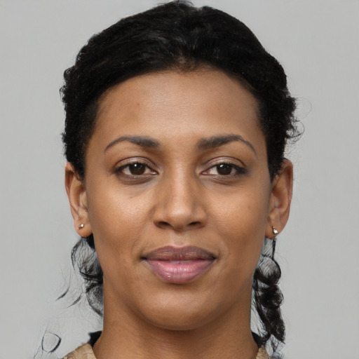 Joyful black young-adult female with short  black hair and brown eyes