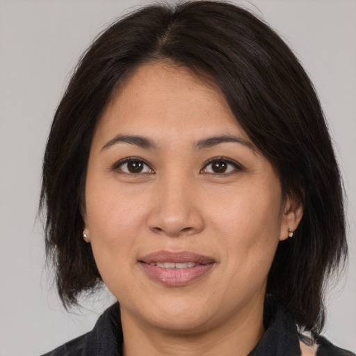 Joyful asian young-adult female with medium  brown hair and brown eyes