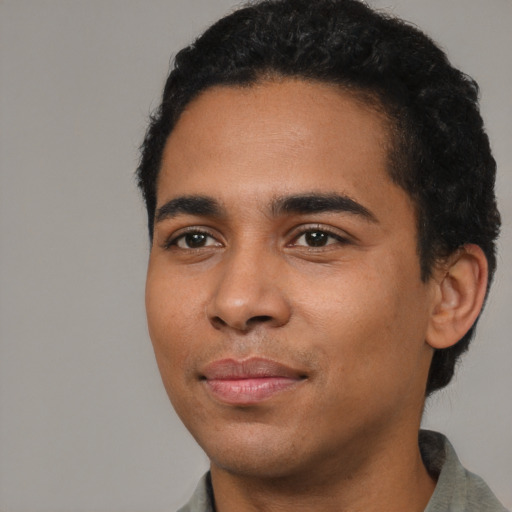 Joyful latino young-adult male with short  black hair and brown eyes