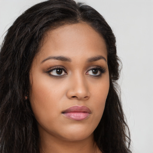 Joyful latino young-adult female with long  brown hair and brown eyes