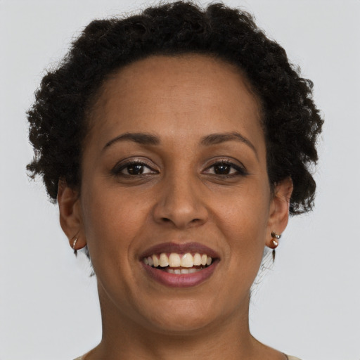 Joyful black young-adult female with short  brown hair and brown eyes