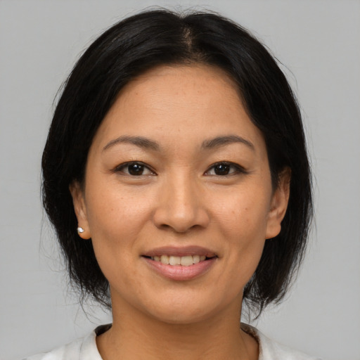 Joyful asian adult female with medium  brown hair and brown eyes