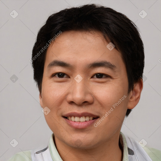 Joyful asian young-adult male with short  brown hair and brown eyes